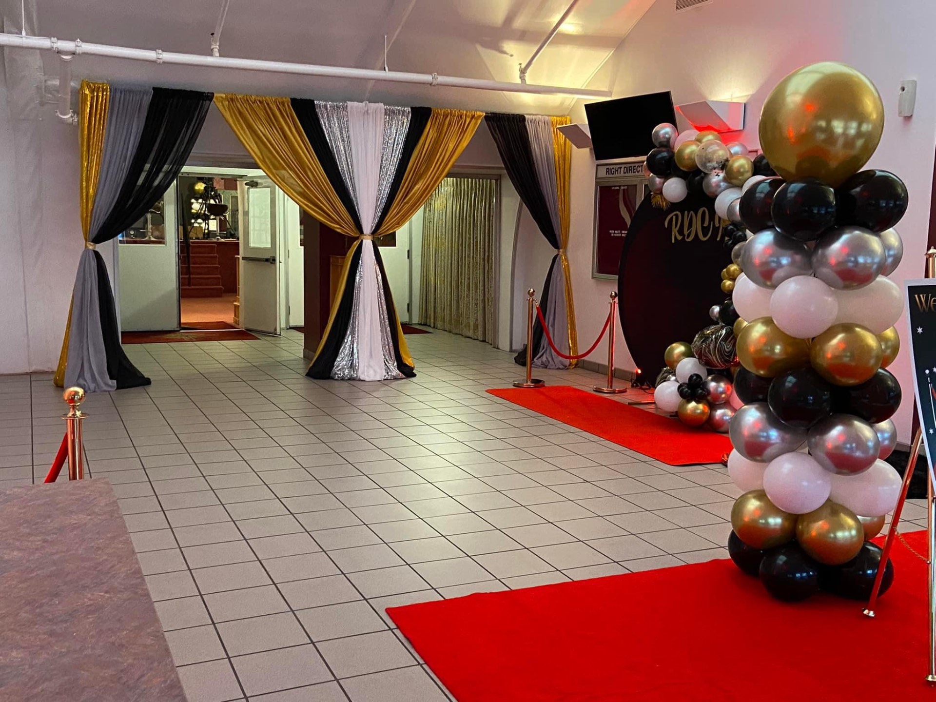 New Year's Eve Red Carpet themed sanctuary entrance with black, white, gold and silver draping, balloon columns and red carpet